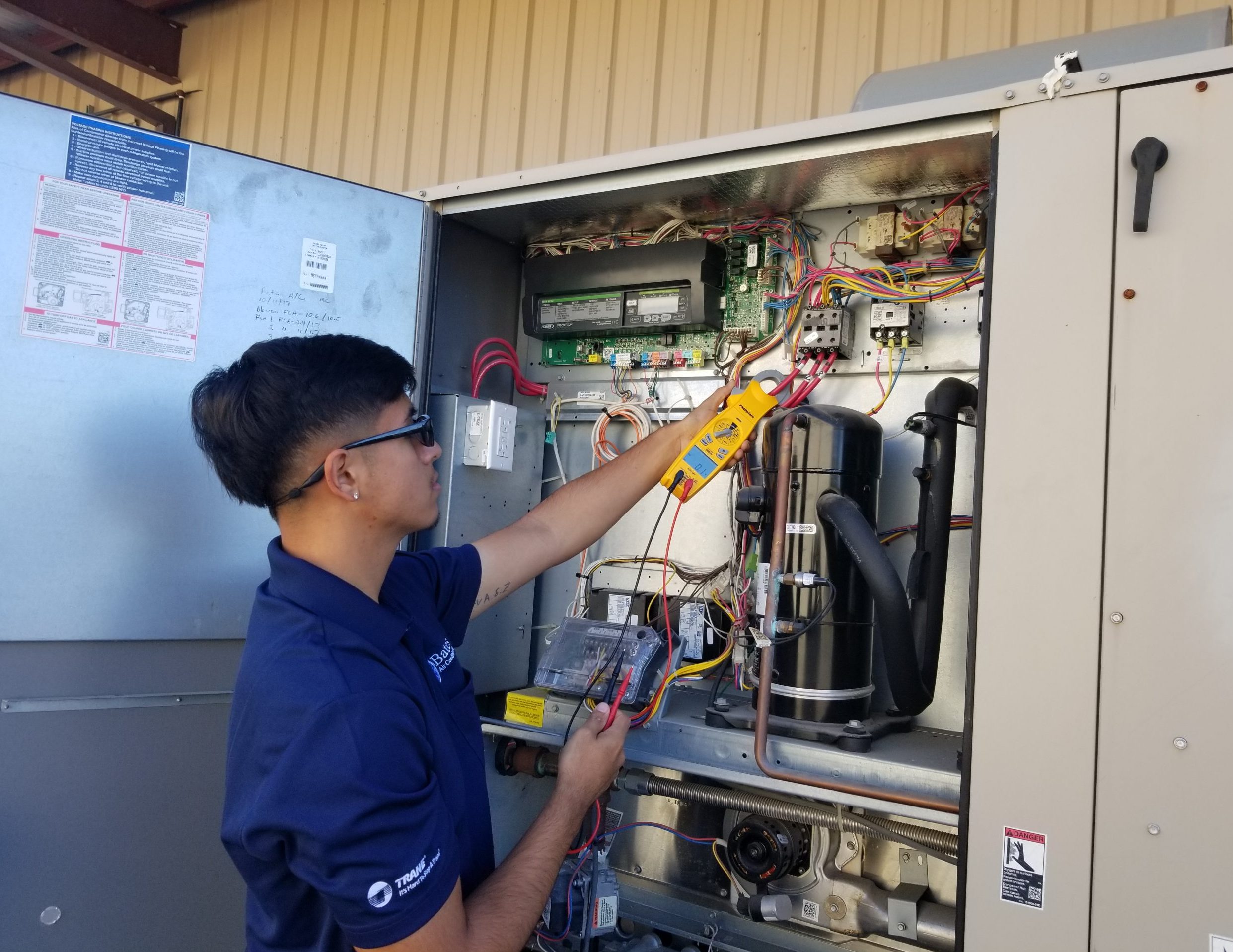 Technician uses a meter to test an HVAC unit